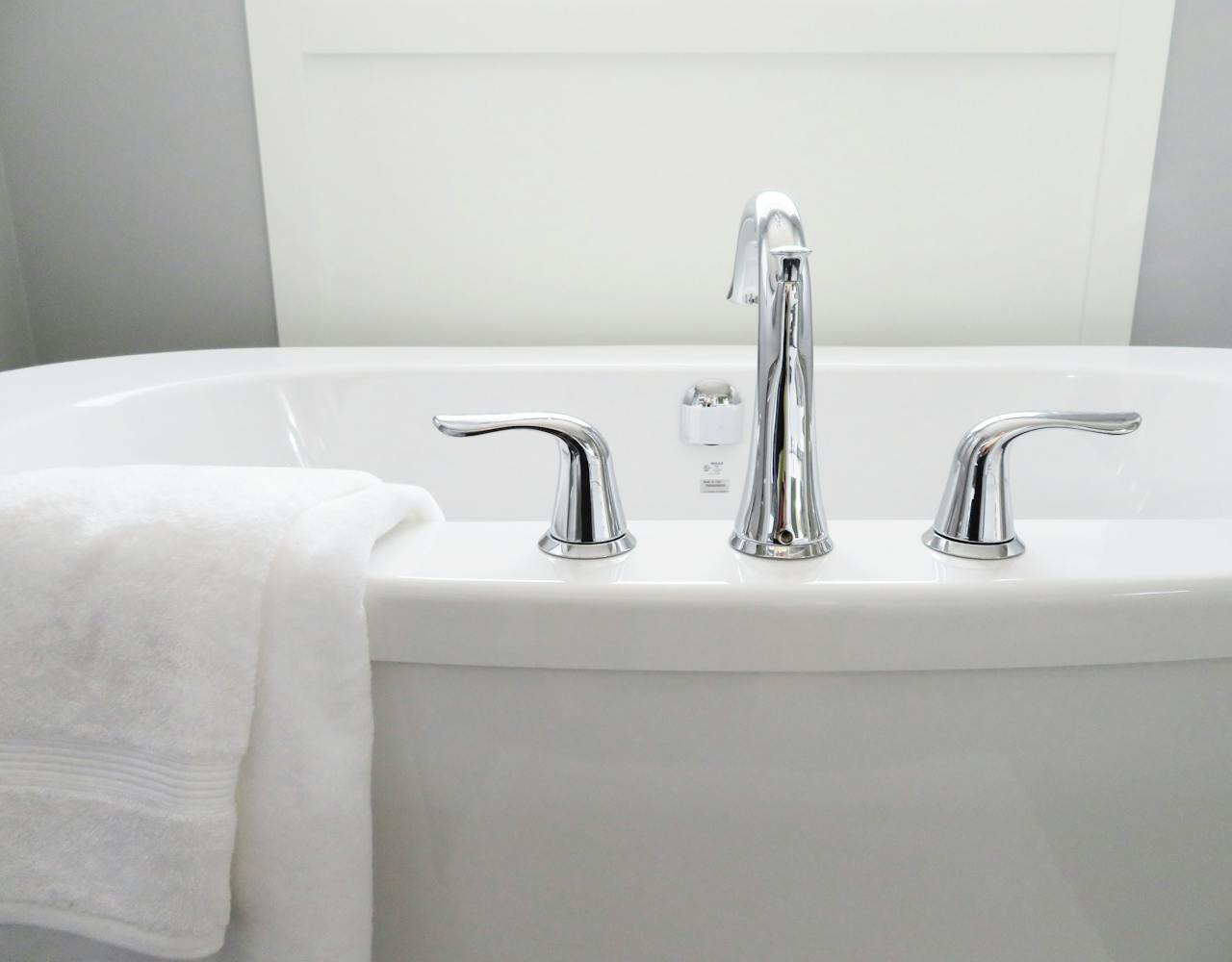 Home Clean and modern white bathtub with chrome fixtures, perfect for sleek interior design.